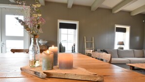 A wooden dining table with candles and a vase of flowers. - Spacious Holiday Home in the Beemster Near a Windmill (Middenbeemster)