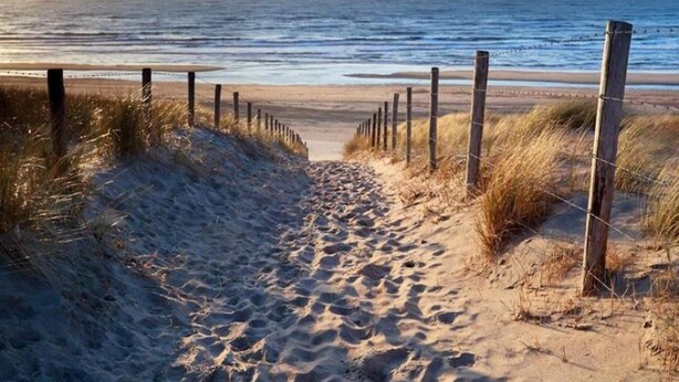 A sandy beach path leading to the ocean, bordered by wooden posts and grass. - Spacious Holiday Home in the Beemster Near a Windmill (Middenbeemster)