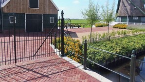 A traditional windmill and a wooden building with a brick pathway in front. - Spacious Holiday Home in the Beemster Near a Windmill (Middenbeemster)