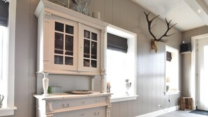 A room with a white cabinet with glass doors, a large window with a view, and a mounted deer skull on the wall. - Spacious Holiday Home in the Beemster Near a Windmill (Middenbeemster)