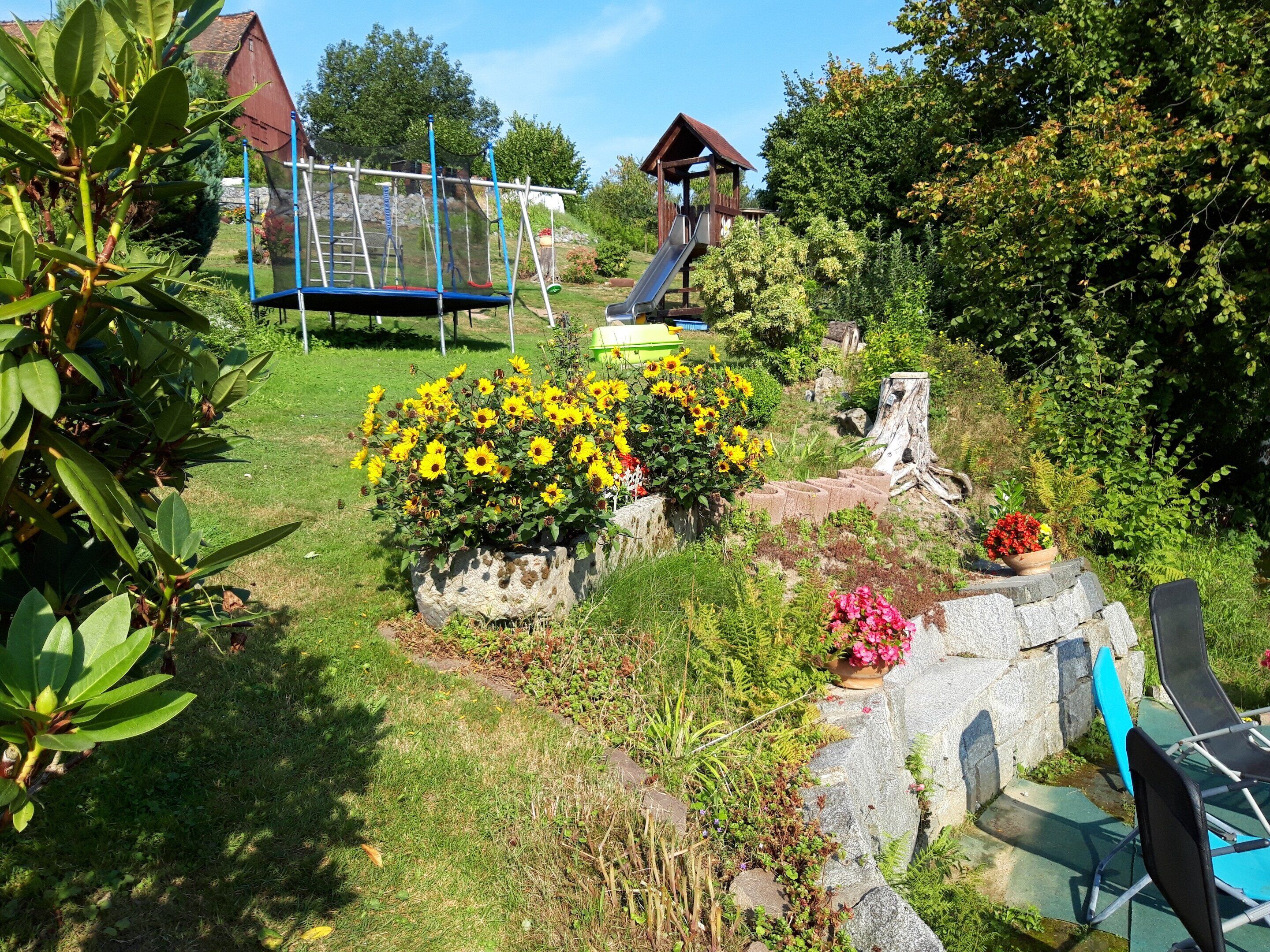 A garden with a playground, including a slide and climbing structures.