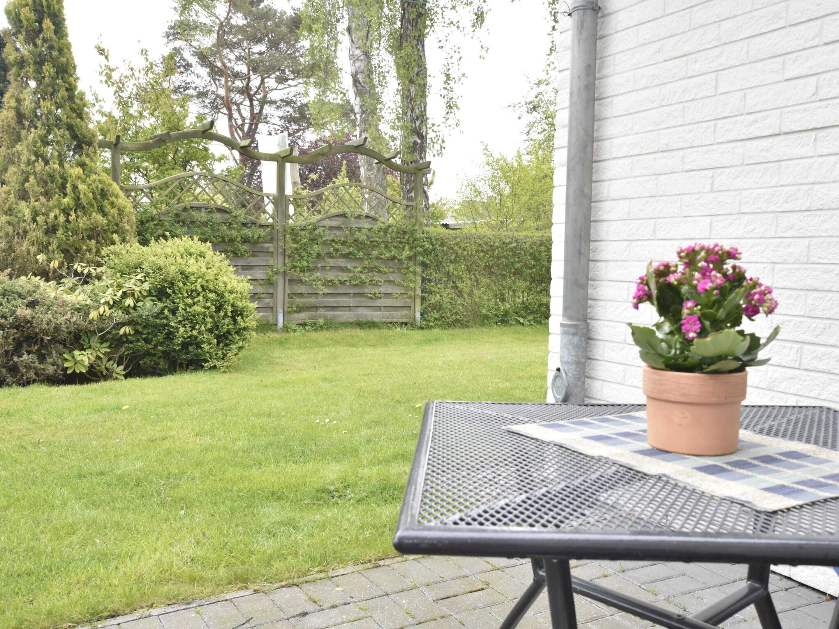 Un espace patio avec une table en métal et une plante en pot.