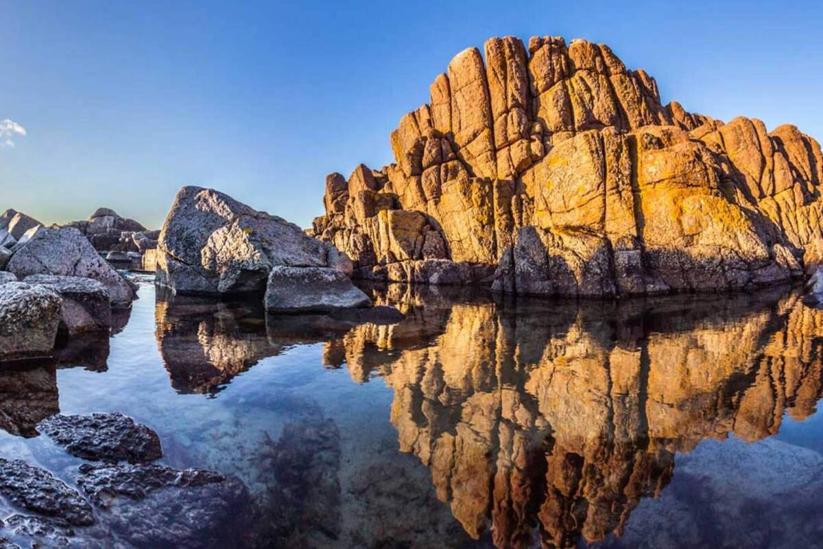 A rocky landscape with clear reflections in calm water.