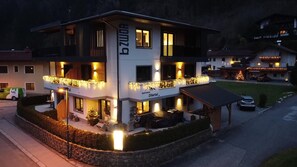 A multi-story hotel with balconies, outdoor seating, and a Christmas tree.