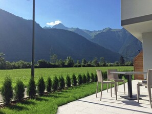A patio with outdoor seating overlooking a mountain landscape.