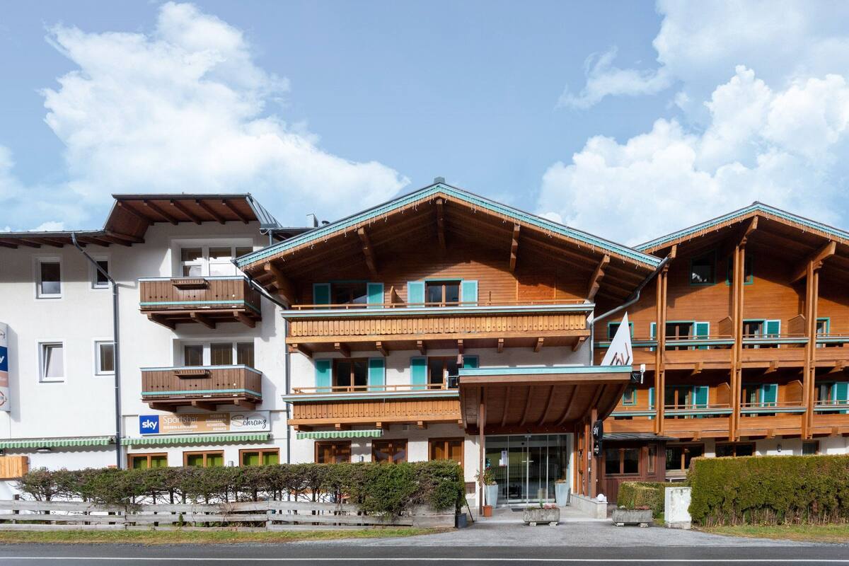 A multi-story hotel with balconies, a ski bar, and a ski lodge sign.