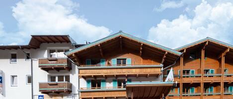 A multi-story hotel with balconies, a ski bar, and a ski lodge sign.
