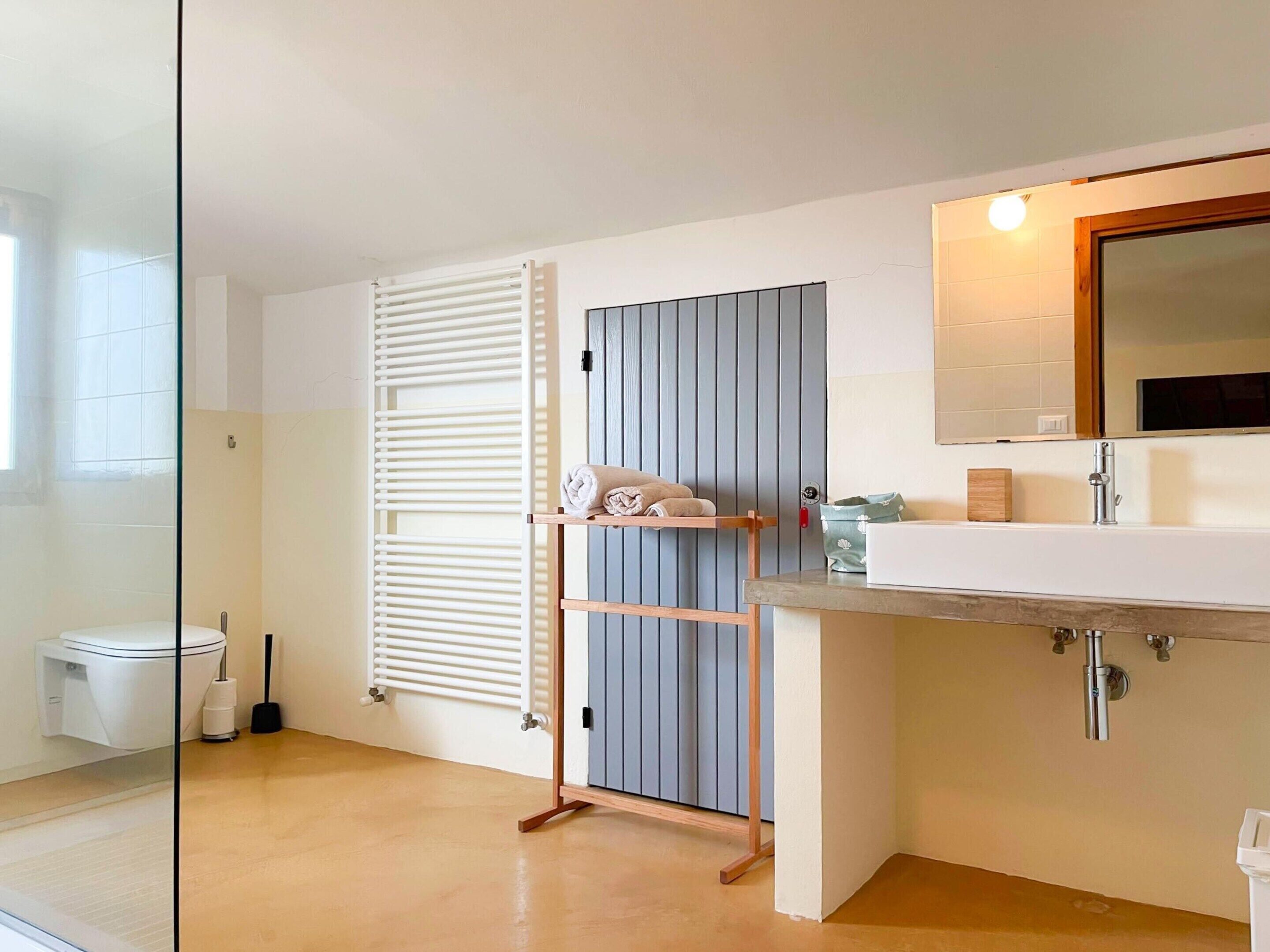 Ein modernes Badezimmer mit Waschbecken, Spiegel und Handtuchhalter.
