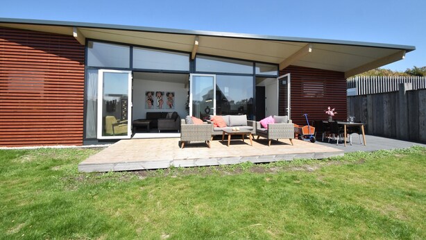 A modern house with a patio, sliding glass doors, and outdoor furniture. - Chic Holiday Home in Callantsoog Forest Nearby (Callantsoog)