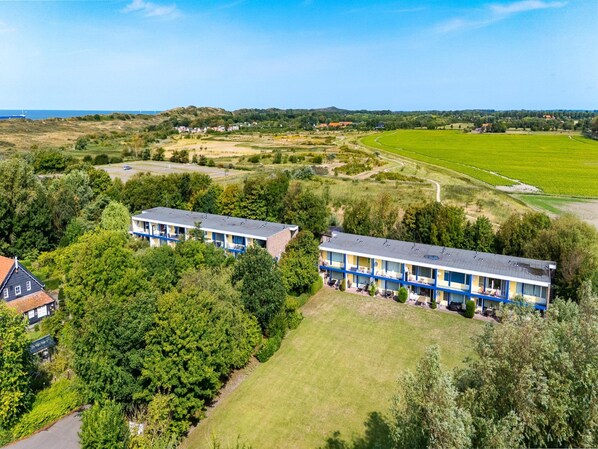 Un hotel con edifici a due piani, immerso nel verde e tra campi.