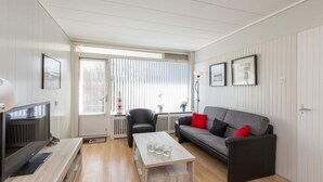 Een moderne woonkamer met een bank, een salontafel en een televisie.