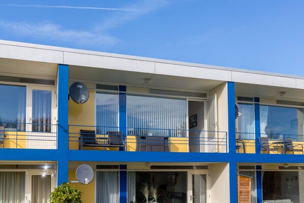 A multi-story building with balconies, satellite dishes, and a clear blue sky. - Attractive Apartment Near Vlissingen Beach (Vlissingen)