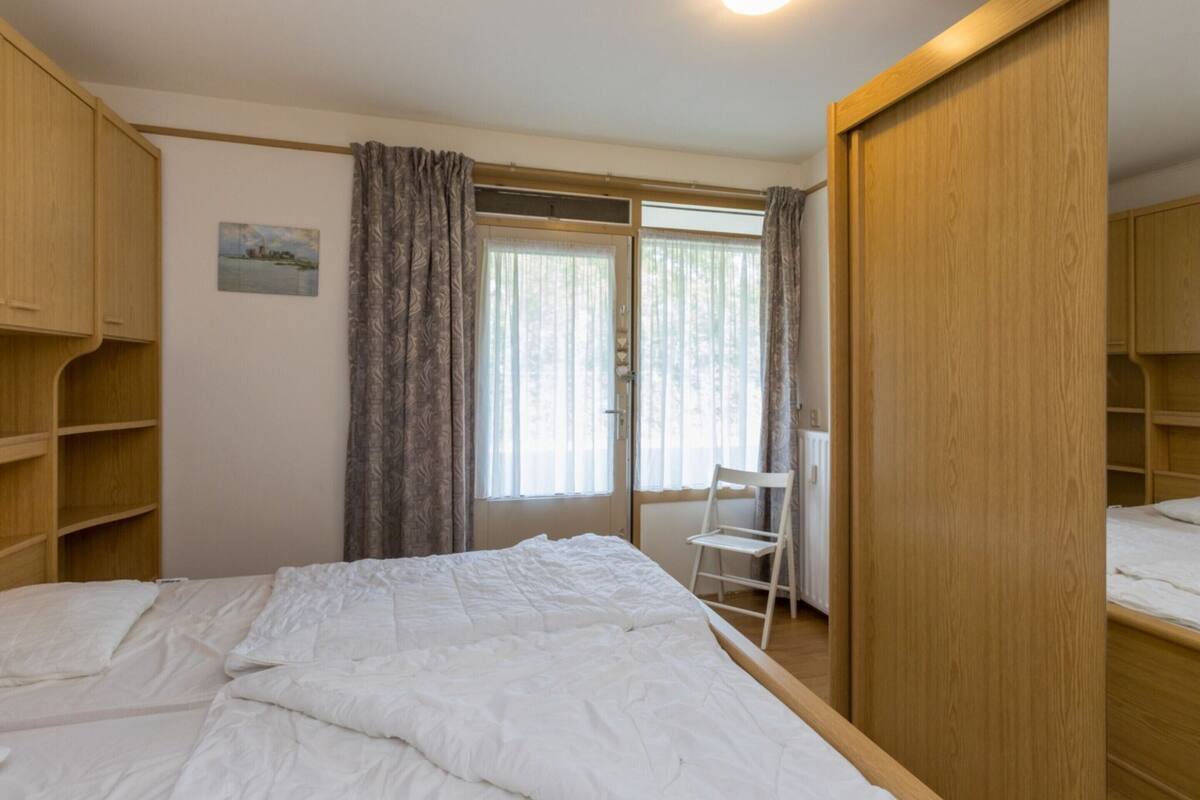 Ein Schlafzimmer mit einem Bett, einem Sessel und einem Kleiderschrank.