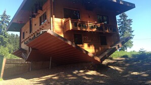 A wooden cabin with a sloped roof, a balcony, and a chimney. - Welcoming Chalet Near Forest in Rohrnbach (Roehrnbach)