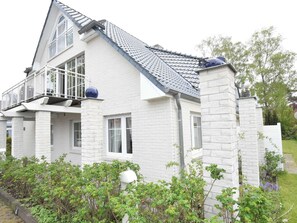 A two-story house with a white exterior, a balcony, and a grey tiled roof. - Cozy Apartment in Zingst Germany Near Beach (Zingst)