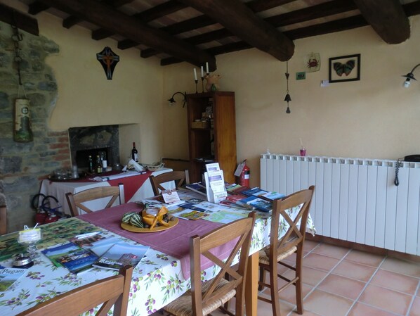 Un coin repas avec une table dressée pour deux personnes, une cheminée et une bibliothèque.