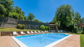 A rectangular swimming pool with a tiled deck, surrounded by lounge chairs and a covered seating area. - Quiet Holiday Home in Sellano With Swimming Pool a few Kilometers From Rasiglia (Sellano)