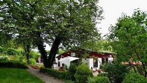 Ein Haus, umgeben von üppigem Grün, mit einem Kiesweg, der zum Eingang führt.