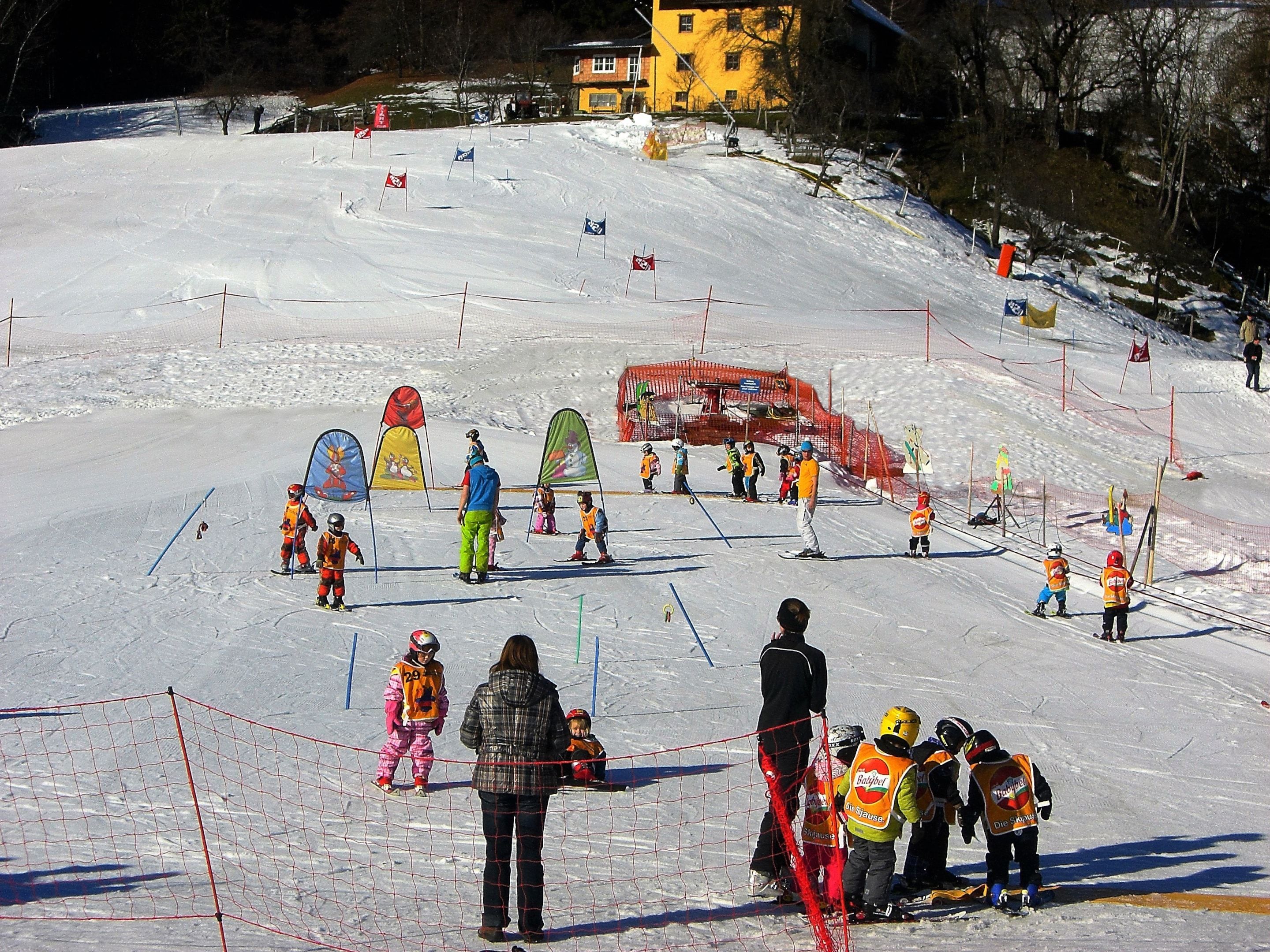 A ski slope with marked lanes and a ski lift in the background.