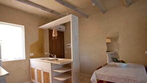 A compact kitchen with a built-in sink, wooden cabinets, and a window. - Stylish one Bedroom Apartment Just a few Steps From the sea (Golfo Aranci)