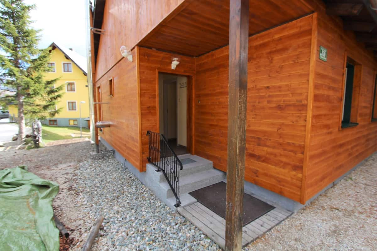 Ein Holzgebäude mit einer Treppe, die zu einem Eingang führt.