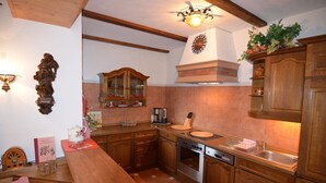 A kitchen with wooden cabinets, a stove, and a sink. - Quaint Apartment in Zeil am Main With Terrace (Zeil)