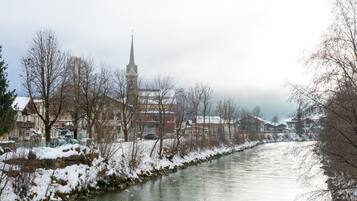 A river with snow-covered banks and buildings in the background.