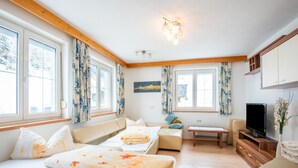 Una habitación acogedora con una cama, un sofá, una mesita y un televisor.