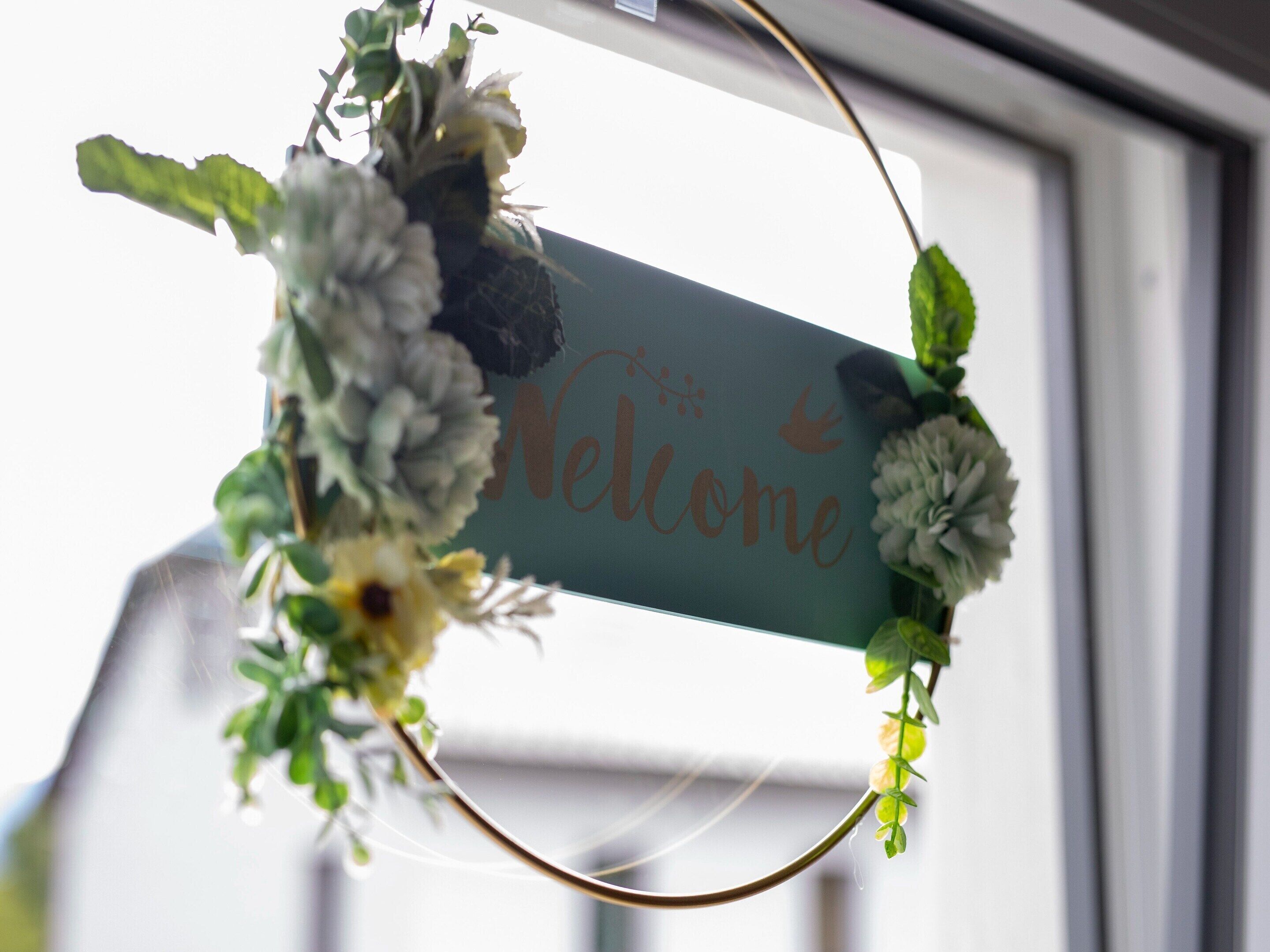 Un letrero de bienvenida con adornos florales.