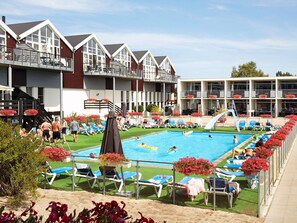Ein Poolbereich mit Liegestühlen und einem Sprungbrett.
