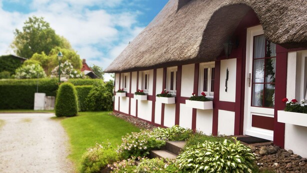 A traditional thatched-roof cottage with a well-maintained garden and a gravel path leading to the entrance. - Ruhiges Appartement in Strandnaehe in Wohlenberg, Deutschland (Klütz)