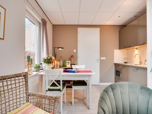 A modern apartment with a dining area, kitchen, and seating space. - Alluring Apartment in Bergen With Terrace, Garden and BBQ (Bergen)