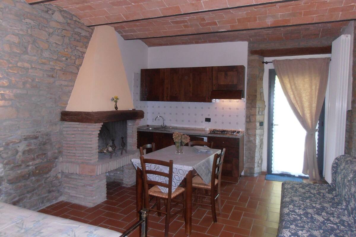 Eine rustikale Küche mit Steinwand, Holzschränken und einer gefliesten Rückwand.