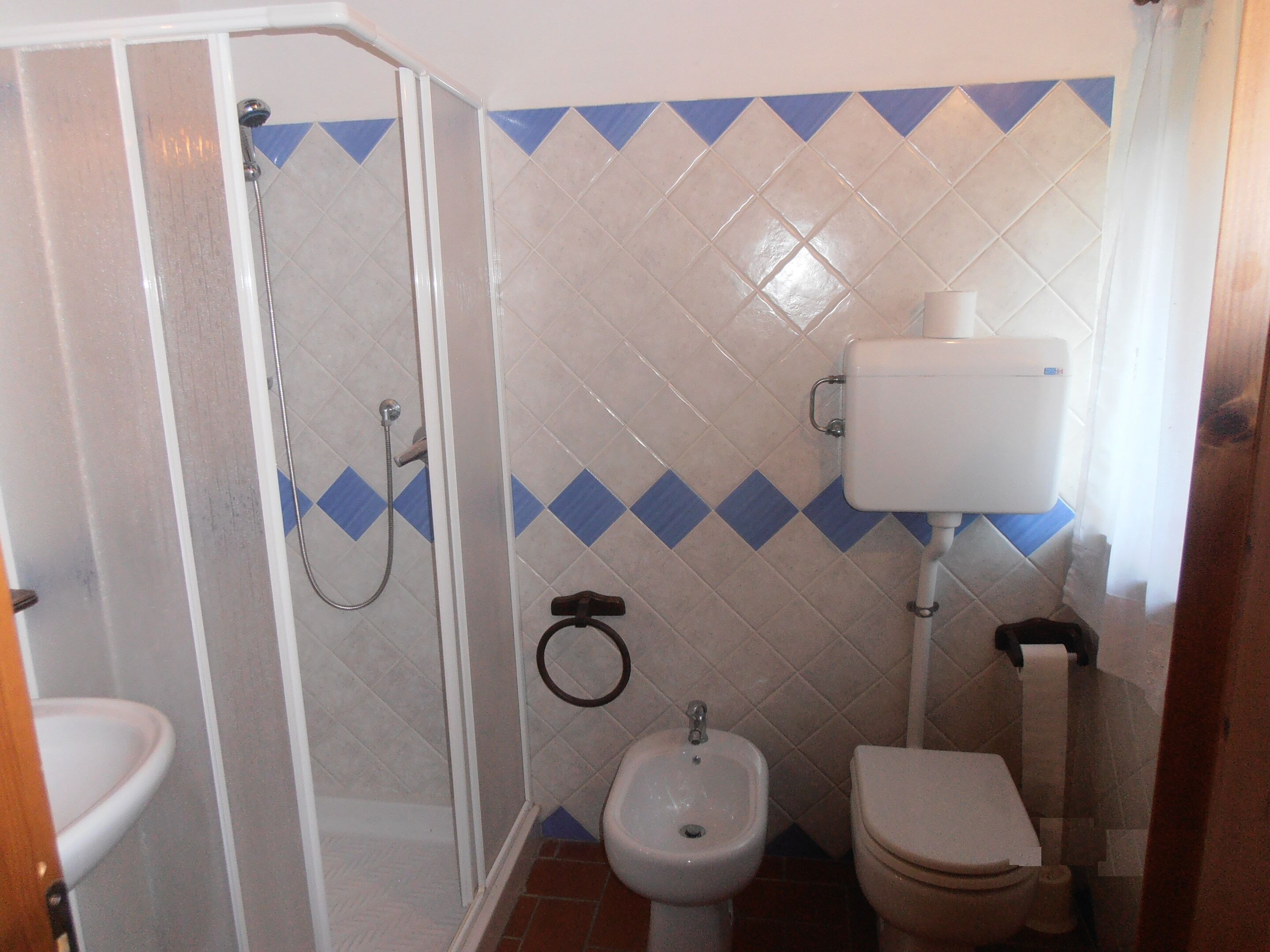 Un baño con ducha, bidé, inodoro y lavabo.