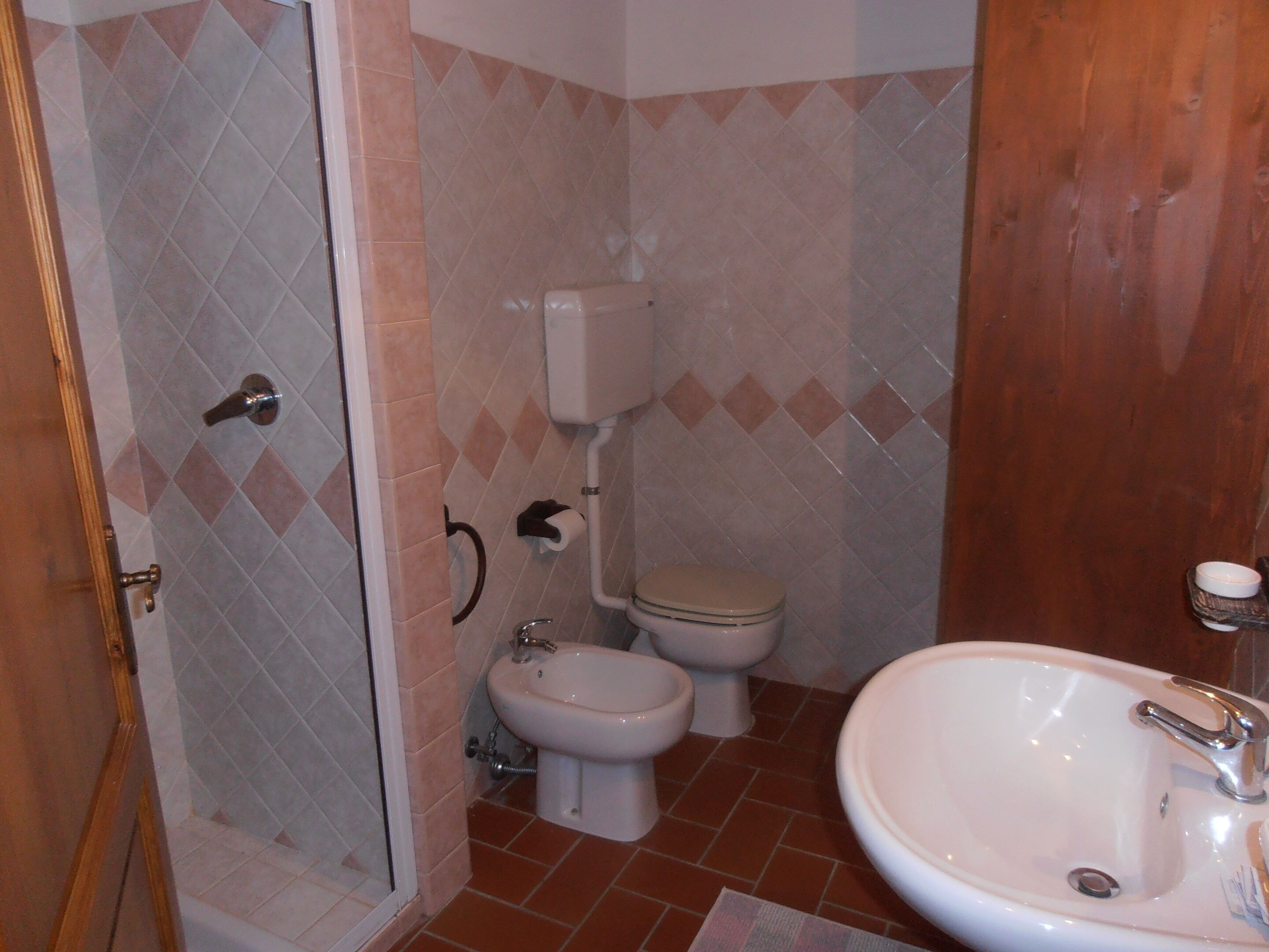 Ein Badezimmer mit Dusche, Toilette, Bidet und Waschbecken.