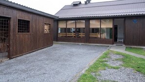 Un bâtiment doté d’une cour en gravier et de murs extérieurs en bois.