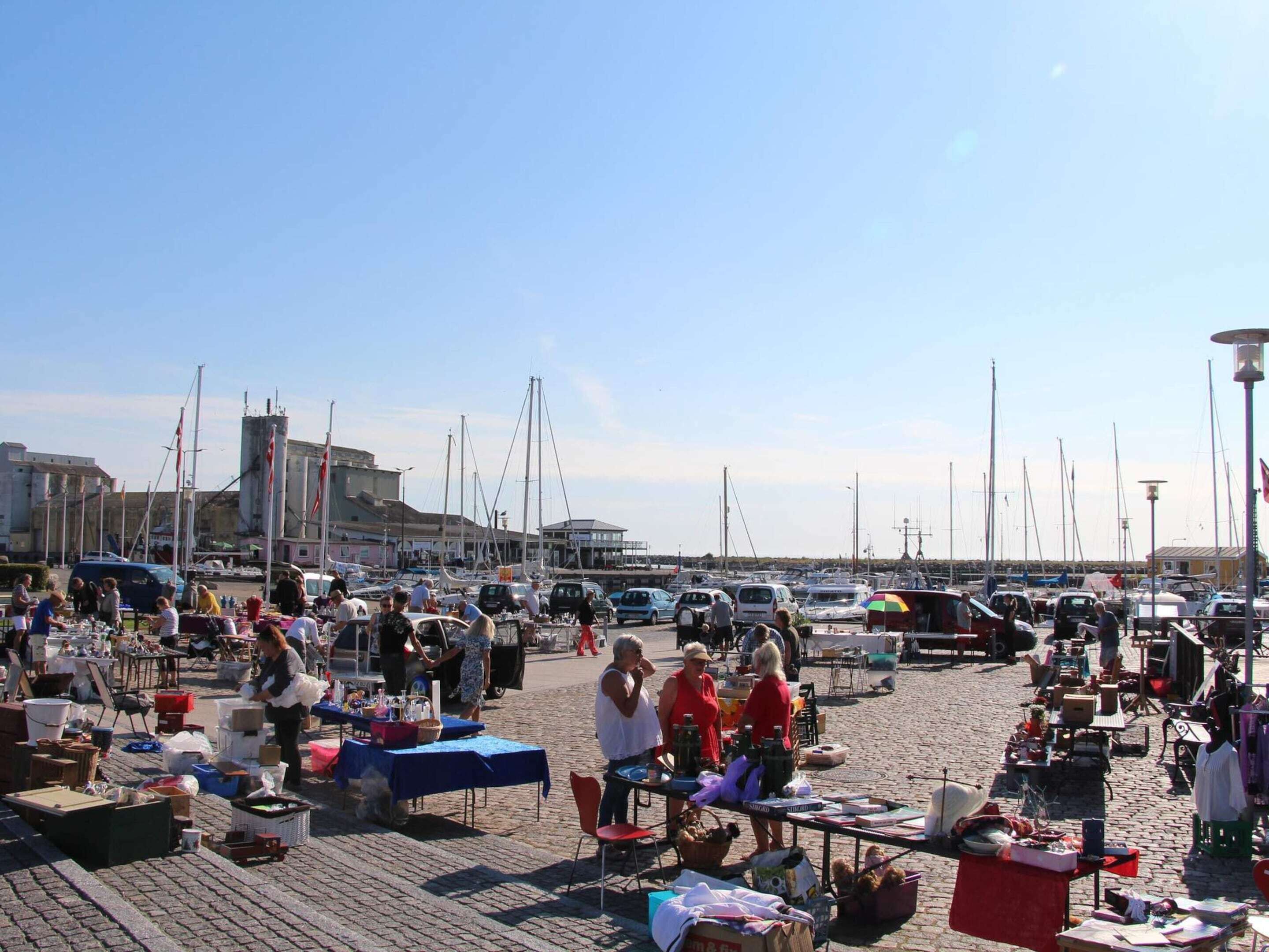 Un marché animé en plein air, avec de nombreux étals et beaucoup de monde.
