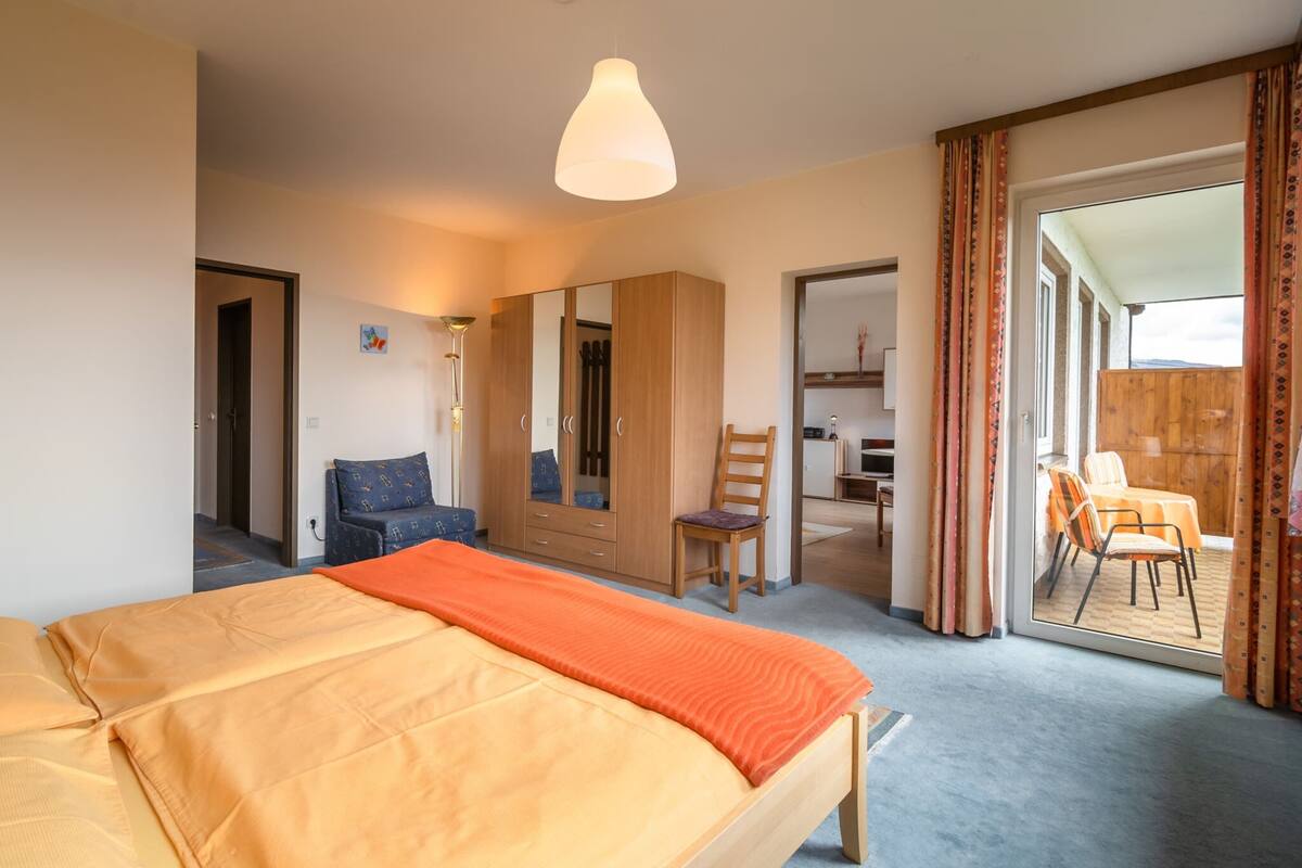 Une chambre à coucher avec un lit, une armoire, une chaise et un bureau.
