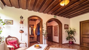 Une pièce avec un plancher en bois, une table blanche sur laquelle est posée une serviette, une chaise rouge et un plafond en bois.