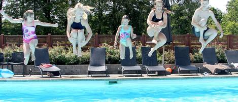 A swimming pool with five people mid-jump.