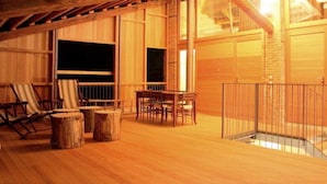 A wooden deck with a table and chairs, a wooden railing, and a large window. - Modern Farmhouse in Pagnano Italy Near Forest (Asolo)