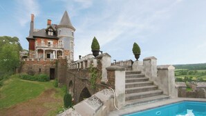 A castle with a swimming pool, stone steps, and a view of the countryside. - Live Your Dream at This Castle in the City of Spa (Jalhay)
