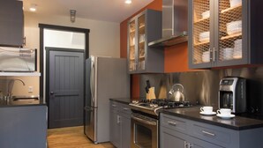 A modern kitchen with stainless steel appliances, a coffee maker, and a kettle on the counter. - Bavarian Chalet 1 - Bavarian-inspired chalet with stylish decor and easy ski acc (Taos Ski Valley)
