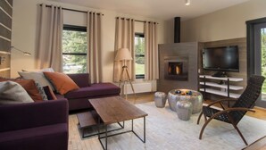 A modern living room with a sofa, coffee table, and a fireplace. - Bavarian Chalet 1 - Bavarian-inspired chalet with stylish decor and easy ski acc (Taos Ski Valley)