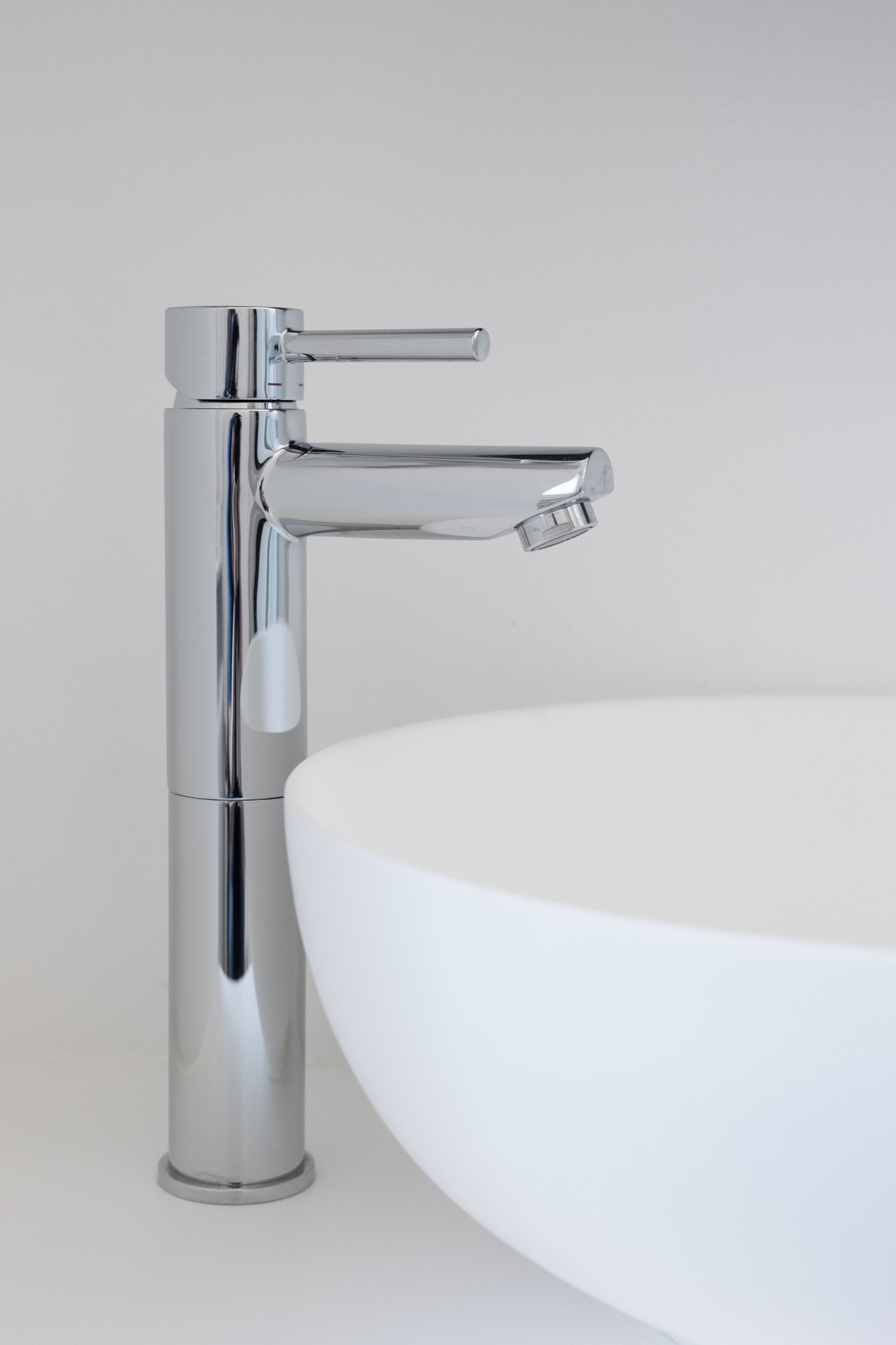 A chrome faucet with a single-handle design and a separate control for hot and cold water.