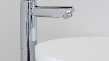 A chrome faucet with a single-handle design and a separate control for hot and cold water.
