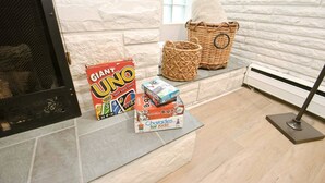 A fireplace area with a Giant UNO card game, a Scrabble set, and a box of Charades for Kids. - Mid Century Modern, 10 min walk to ND! (1831) (South Bend)