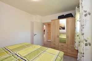 Una camera da letto con un letto, un armadio e una porta che dà su un'altra stanza.