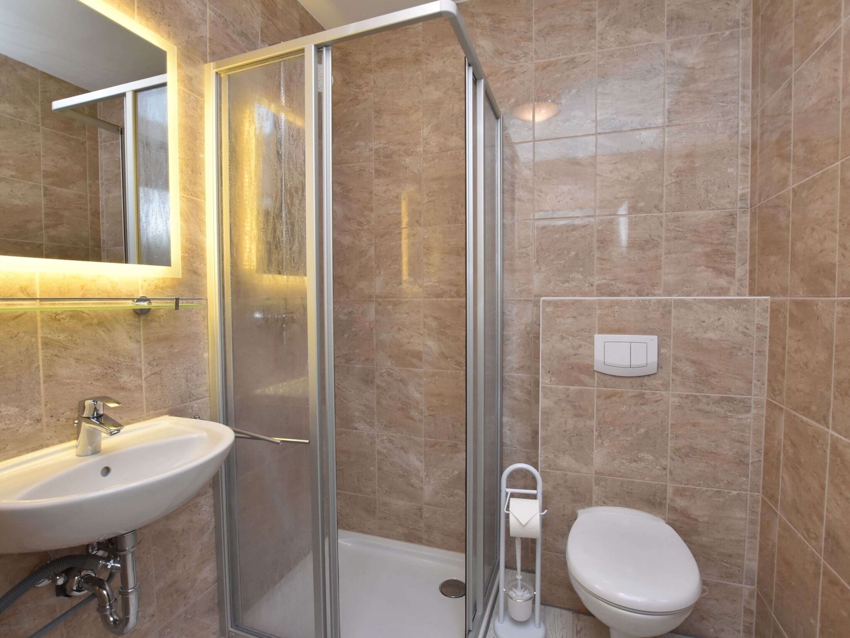 Ein Badezimmer mit einer Duschkabine, einem Waschbecken und einer Toilette.