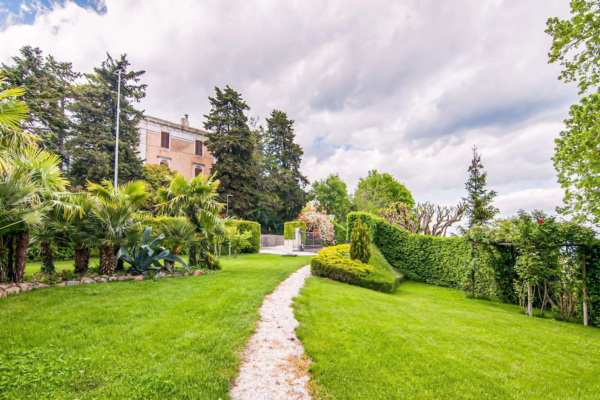 A well-maintained garden with a gravel path leading to a building.